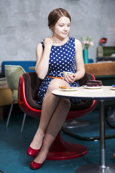 Femme en robe blanche tachetée tenir tasse — Photo