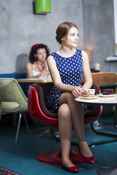 Vrouw in witte gevlekte jurk in café — Stockfoto