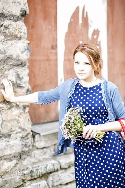 Kvinna i klänning hålla bunt av blommor — Stockfoto