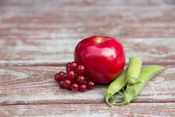 Ripe foxberry red apple and pea pods — Stock Photo, Image
