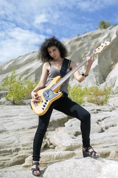 Woman play yellow bass guitar on background — Stock Photo, Image