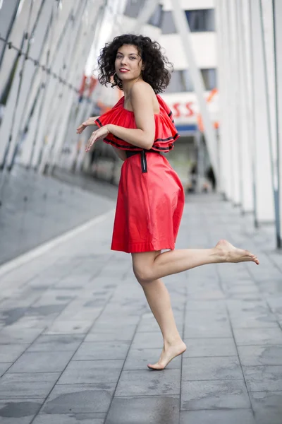 Mujer en vestido rojo imitando carrera —  Fotos de Stock