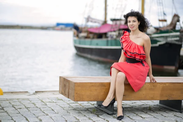 Woman in red dress posing at harbor — Stock Photo, Image