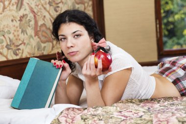 Woman hold bitten apple and look questionable