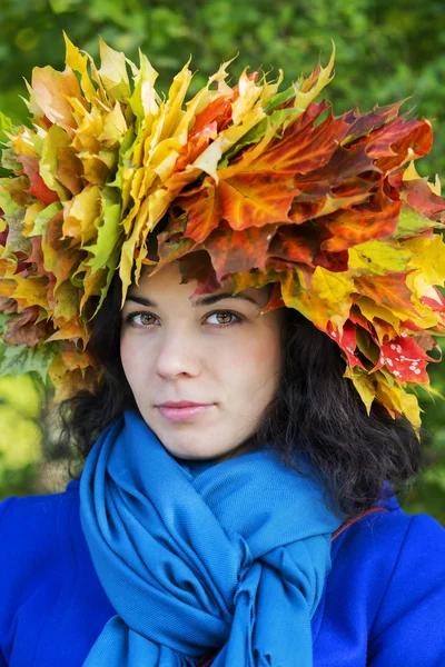 Kvinna med blad på huvudet ser raka — Stockfoto
