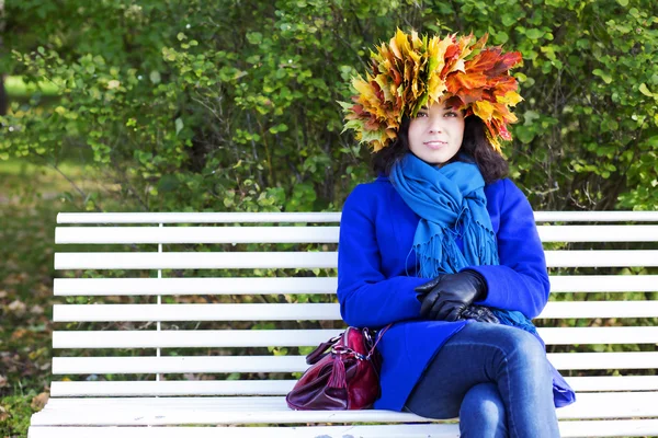 Jonge vrouw met esdoorn bladeren op hoofd — Stockfoto