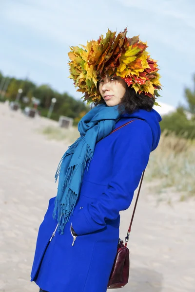 Woman in coat with maple leaves — Stock Photo, Image