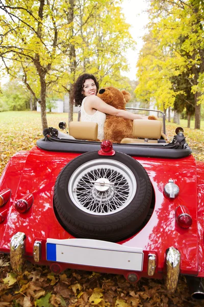 Vrouw plas speelgoed op auto in het park — Stockfoto