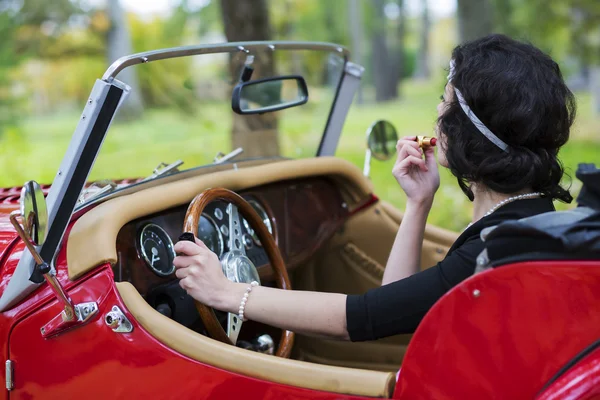 Woman stains the lips and hold wheel — Stock Photo, Image