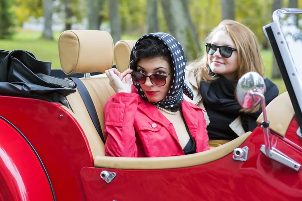 Naiset retro punainen auto näyttää tyytyväiseltä — kuvapankkivalokuva