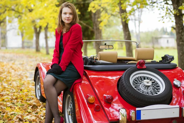 Mulher de vermelho e carro no parque — Fotografia de Stock