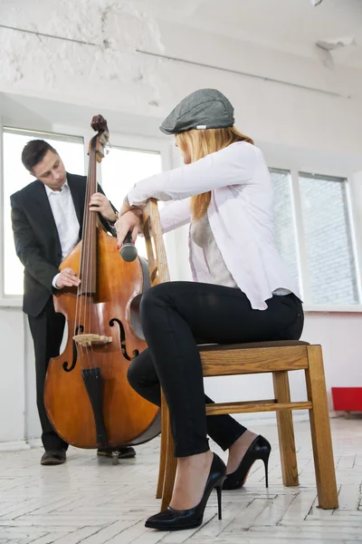 Woman backwards on chair listen contrabass play — Stock Photo, Image