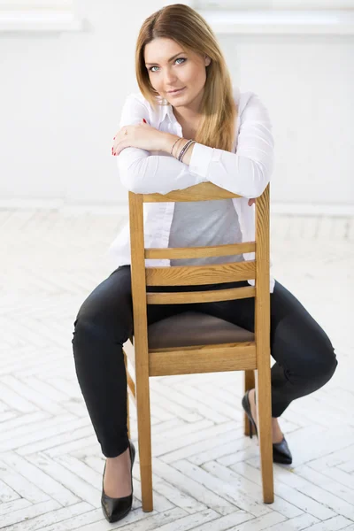 Kadın beyaz oturmak sandalye üzerinde geriye doğru — Stok fotoğraf