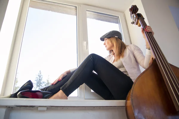 Vrouw op vensterbank op zoek buiten op straat — Stockfoto