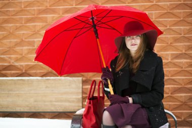 kadın kırmızı çanta ve şemsiye ile