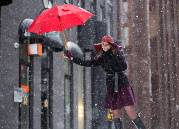 Frau mit rotem Regenschirm und rosa Hut — Stockfoto