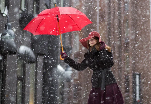 Frau am Wintertag mit rotem Regenschirm — Stockfoto