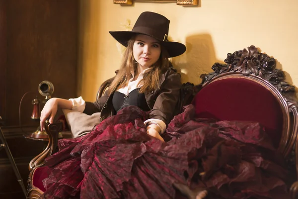 Satisfied woman rests on expensive renaissance furniture — Stock Photo, Image