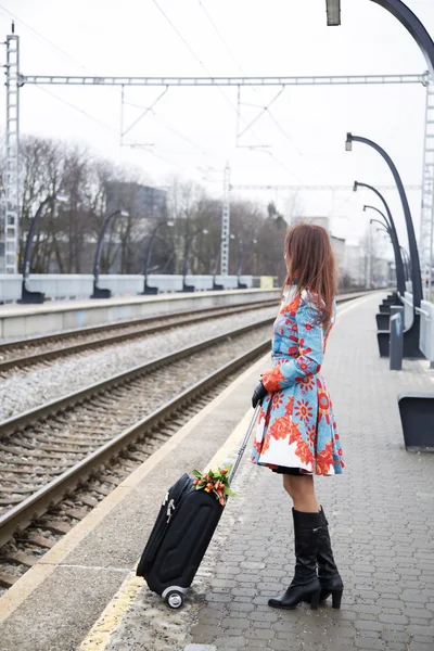 女人在等火车，看另一个方向 — 图库照片