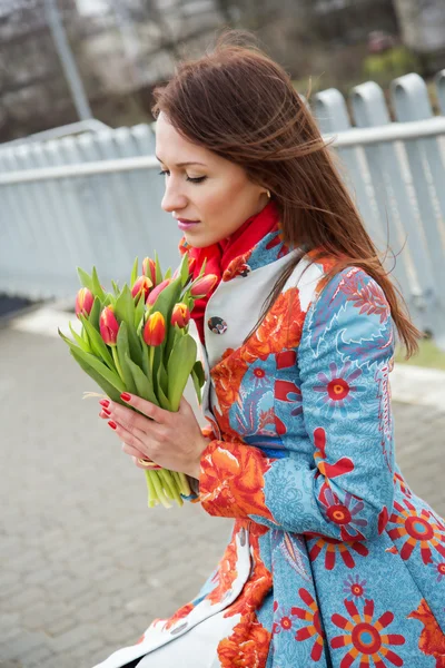 Kvinna på plattform med bunt av blommor — Stockfoto