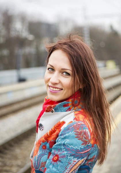 Jonge vrouw op winderige dag op platform — Stockfoto