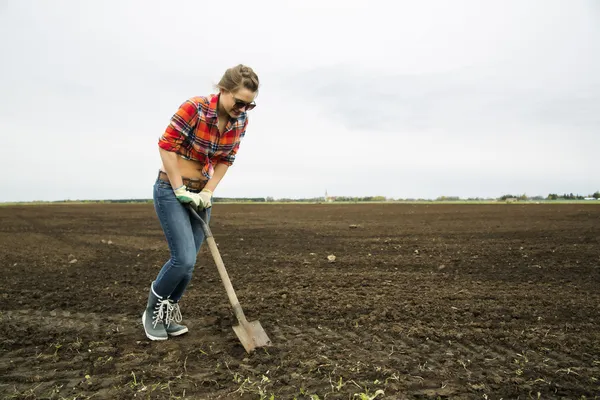 Женщина с острой лопатой попробуйте копать землю — стоковое фото