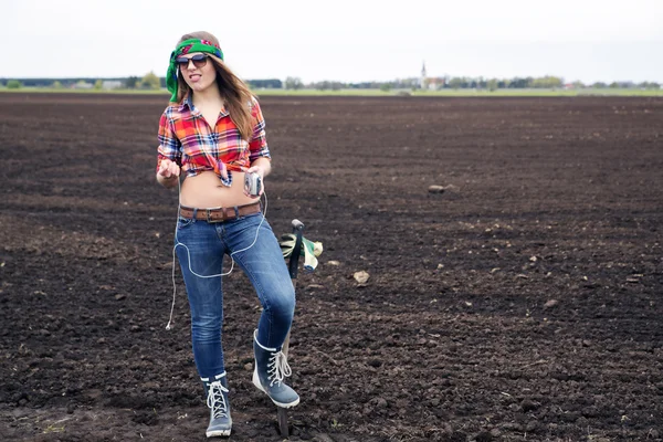 Vrouw luisteren muziek van ipad op veld — Stockfoto