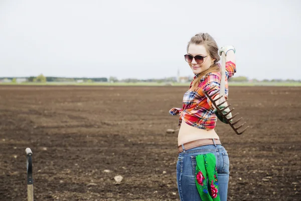 Woman with rake and part of shovel — Stock Photo, Image