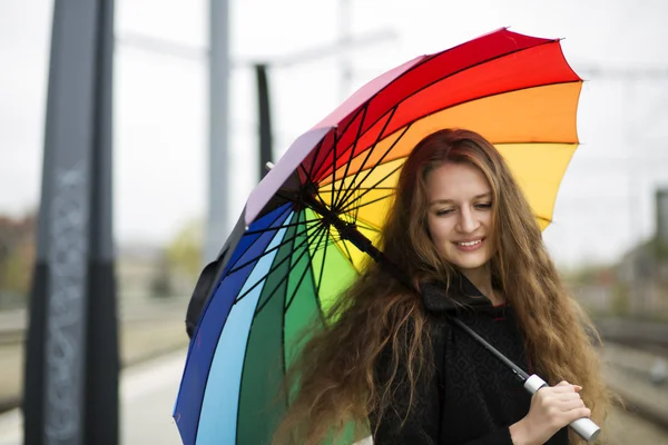 Vrouw met paraplu bij de hand op station — Stockfoto