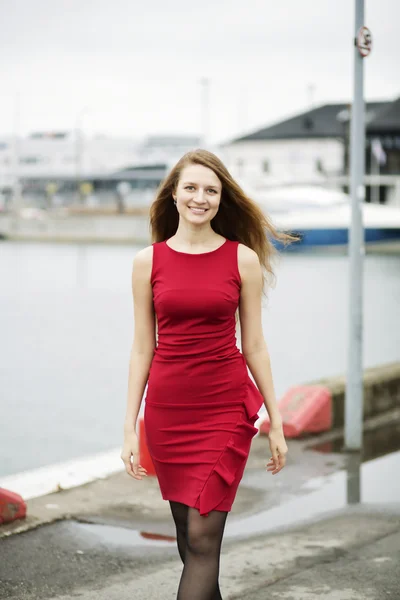 Woman at red dress walk on wharf — Stock Photo, Image