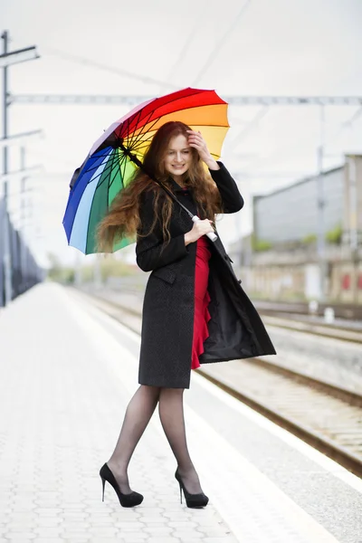 Vrouw met paraplu past haar haren — Stockfoto