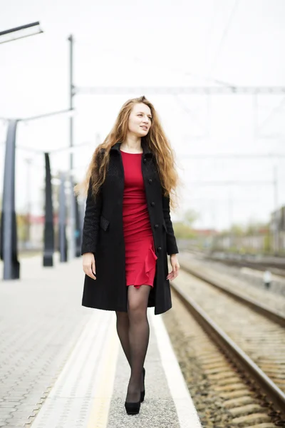 Mulher em vestido vermelho na plataforma de trem — Fotografia de Stock