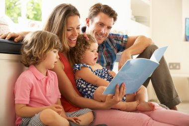 Parents Sitting With Children Reading Story clipart