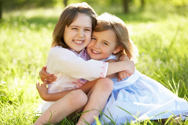 Duas meninas dando um ao outro abraço no campo de verão — Fotografia de Stock