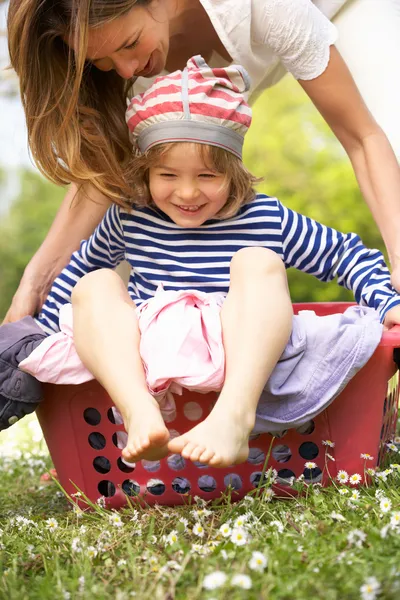 Mãe transportando filho sentado na cesta de lavanderia — Fotografia de Stock