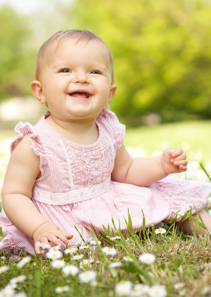 Baby flicka i sommarklänning sitter i fältet — Stockfoto