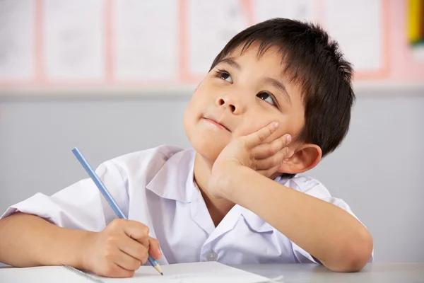 Homme étudiant travaillant au bureau dans la salle de classe de l'école chinoise — Photo