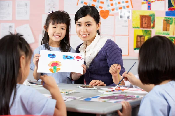 Professor ajudando os alunos durante a aula de arte na escola chinesa Clas — Fotografia de Stock