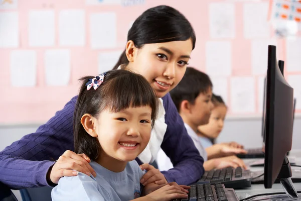 Учитель помогает студенту во время компьютерных занятий в китайской школе — стоковое фото