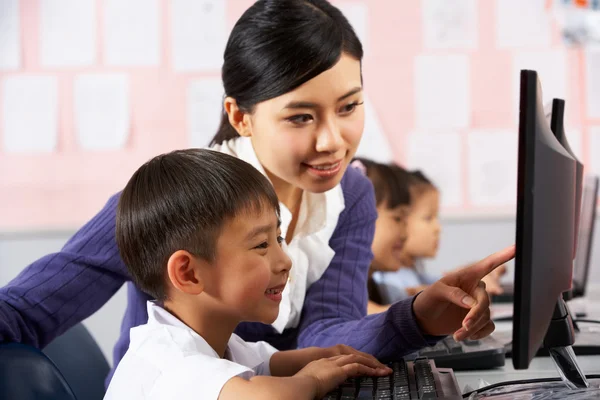 Professor ajudando o aluno durante a aula de informática na escola chinesa — Fotografia de Stock