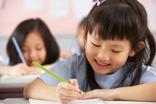 Groep studenten werken bij bureaus in chinese school klas — Stockfoto