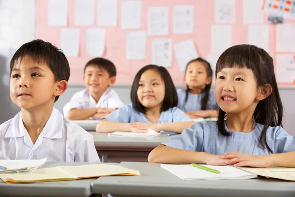 Grupo de estudiantes que trabajan en escritorios en el aula de la escuela china — Foto de Stock