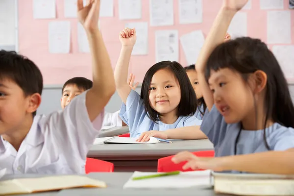 Gruppe von Schülern, die an Schreibtischen im chinesischen Klassenzimmer arbeiten — Stockfoto