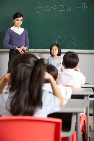 Allievo e insegnante in piedi vicino alla lavagna nella classe della scuola cinese — Foto Stock