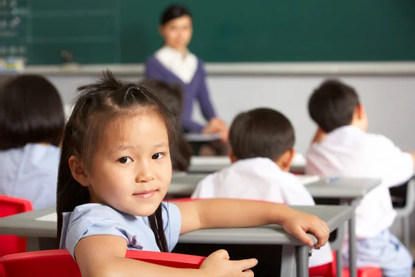 Porträt einer Schülerin, die in einer chinesischen Schulklasse am Schreibtisch arbeitet — Stockfoto