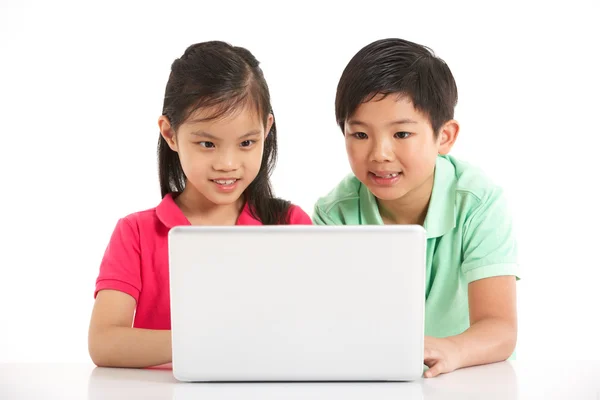 Estudio de tiro de dos niños chinos con ordenador portátil — Foto de Stock