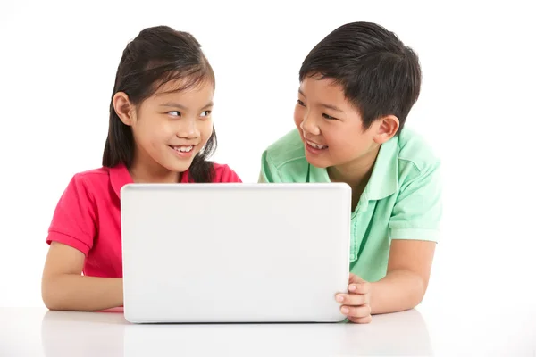 Studioaufnahme von zwei chinesischen Kindern mit Laptop — Stockfoto