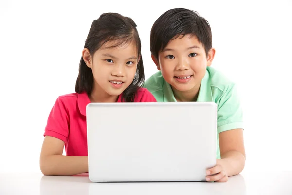 Tiro de estúdio de duas crianças chinesas com laptop — Fotografia de Stock