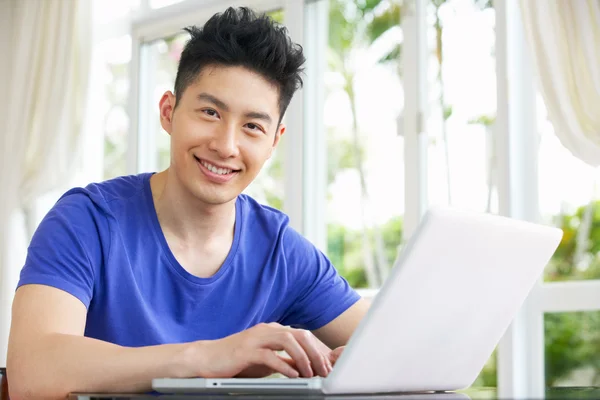 Young Chinese Man Sitting At Desk Using Laptop At Home — Stock Photo, Image