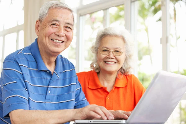 Senior chinese paar zit aan bureau met behulp van laptop thuis — Stockfoto